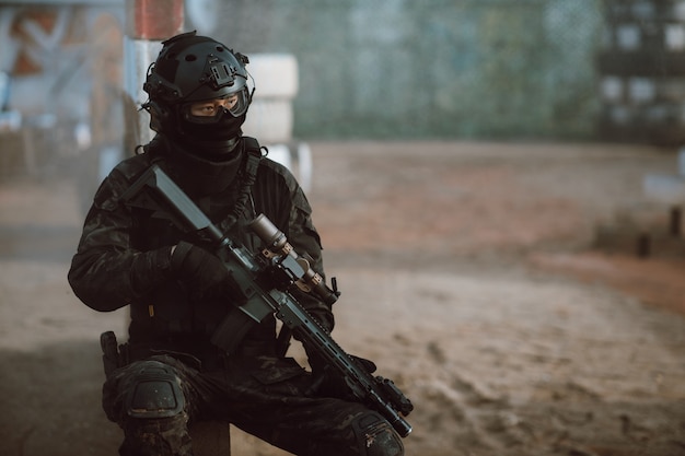 Soldado segurando o rifle na luta pronta da área do campo de batalha. Conceito de estilo de guerreiro de combate com arma de BB.