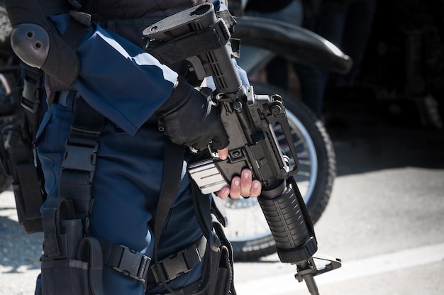 Soldado segurando uma máquina com arma automática. Preparação para ação militar. Soldado vestido com equipamento de proteção