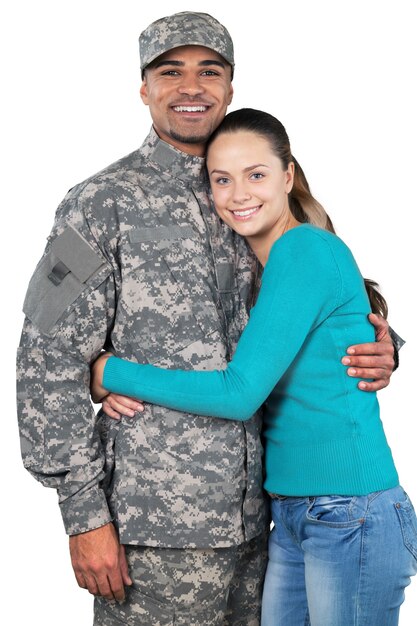 Soldado sonriente con su esposa de pie contra el fondo blanco.