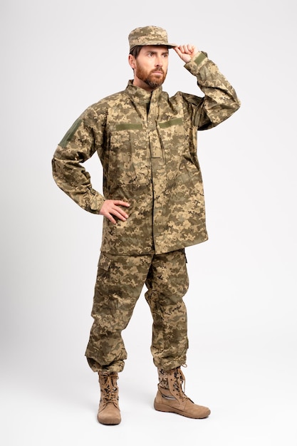 Soldado con uniforme militar de camuflaje mirando hacia otro lado aislado sobre un fondo blanco