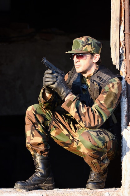 El soldado de uniforme tiene una pistola.