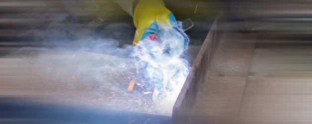 Foto soldador haciendo soldadura en un sitio en construcción