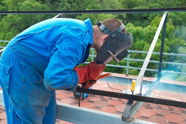 Soldador trabajando con construcción metálica