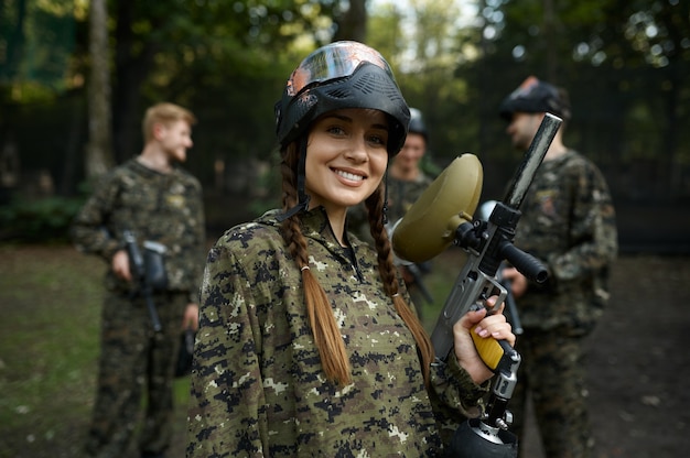 Foto soldados en camuflaje y máscaras jugando paintball, guerra en el patio de recreo en el bosque. deporte extremo con arma neumática y balas de pintura o marcadores, juego de equipo militar al aire libre, tácticas de combate