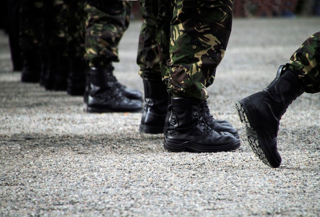 Soldados en un desfile militar con botas y ropa de camuflaje