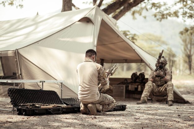 Foto soldados em uniformes de camuflagem planejando uma operação no acampamento