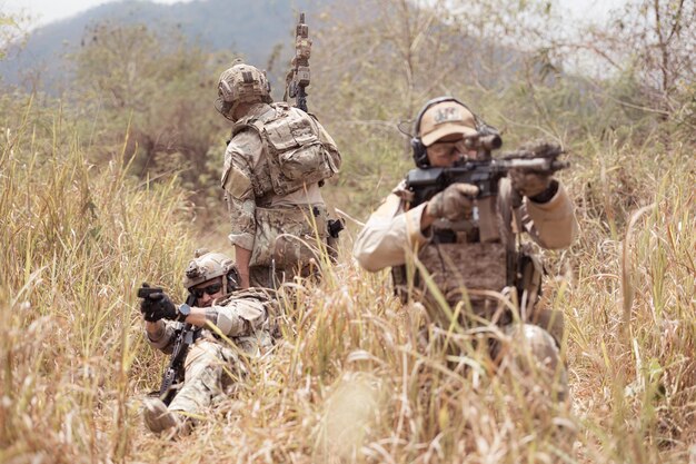 Foto soldados em uniformes militares de camuflagem carregando armas missões de reconhecimento