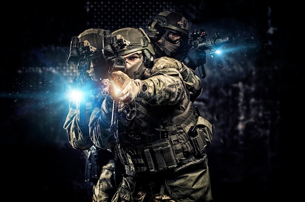 Los soldados estadounidenses con munición de combate con armas en manos de miras láser equipadas están en orden de batalla. Técnica mixta