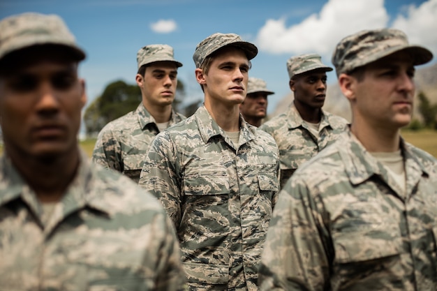 Foto soldados militares de pie en el campo de entrenamiento