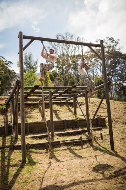 Soldados militares treinando escalada em corda