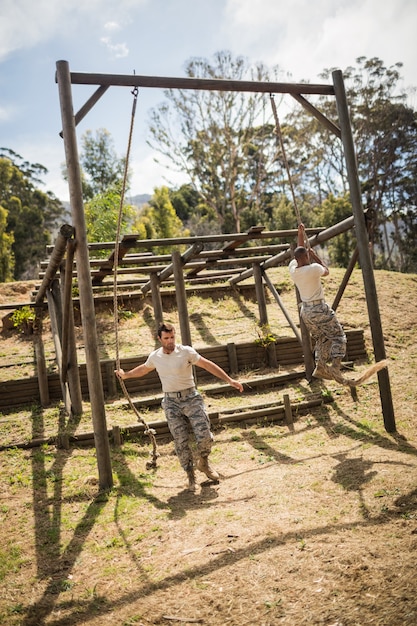 Soldados militares treinando escalada em corda