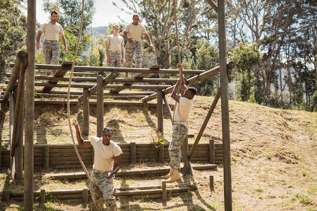 Soldados militares treinando escalada em corda