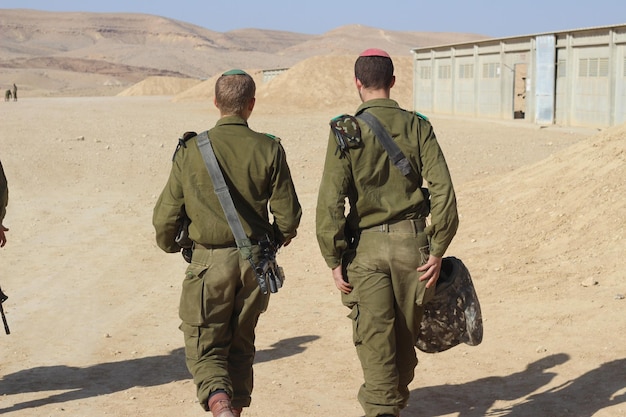 Soldados sírios caminhando no deserto por trás