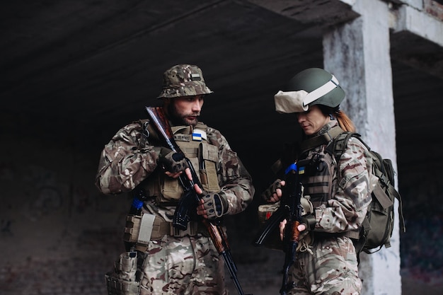 Soldados ucranianos totalmente equipados y armados revisando su equipo mientras toman un descansoxA