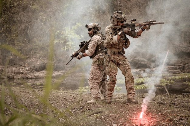 Soldados con uniformes de camuflaje apuntando con sus rifles