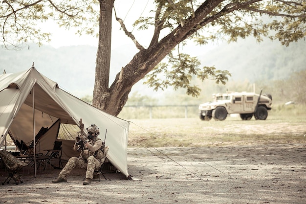 Soldados con uniformes de camuflaje planeando una operación en el campamento