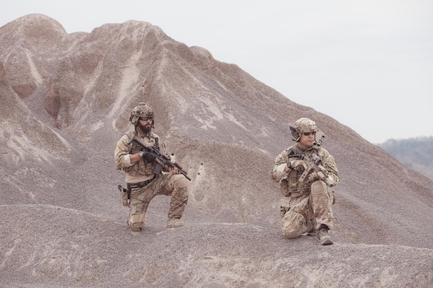 Soldados con uniformes militares de camuflaje que llevan armas Misiones de reconocimiento