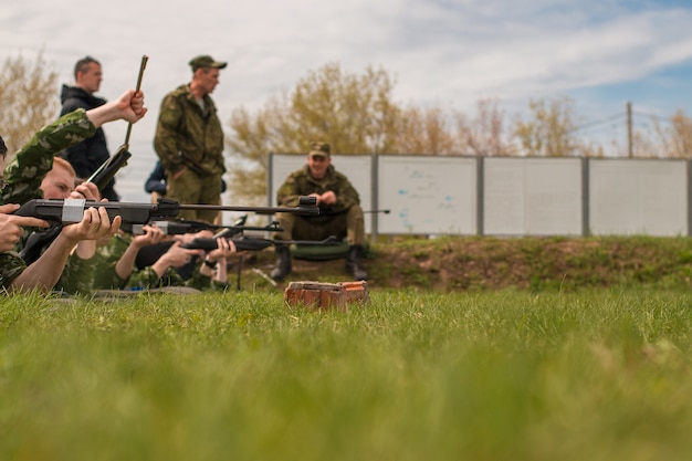 Los soldados yacen en el suelo y apuntan al objetivo. Ejercicios del ejército.