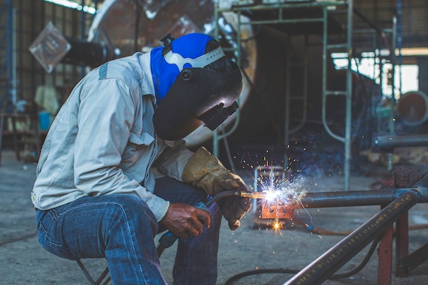 Soldadura de metal trabajador masculino es parte de la maquinaria de construcción de tuberías de boquillas de petróleo y gas