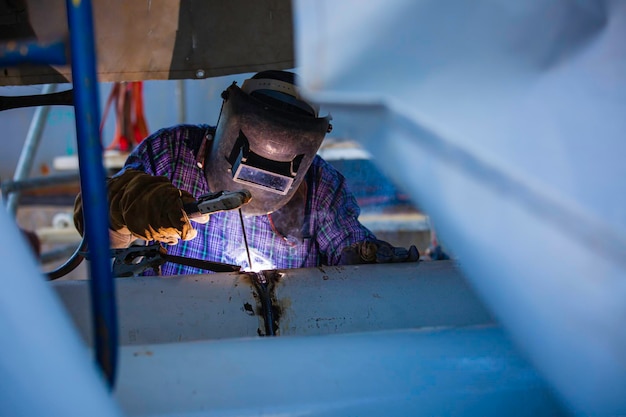 Soldadura de metal trabajador masculino es parte de la maquinaria de construcción de tuberías de boquillas de petróleo y gas