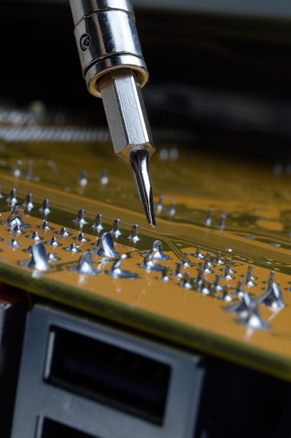 Soldadura de placa de circuito electrónico con componentes electrónicos. Los ingenieros reparan la placa de circuito con soldador.