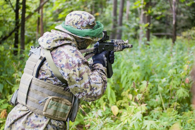 Soldat im Wald mit einem Maschinengewehr. Aus- und Weiterbildung von Soldaten. Der Mann ist bereit zu schießen