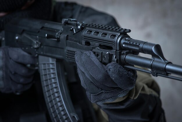 Soldat in Sturmhaube mit automatischem Gewehr in den Händen