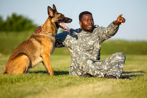 Soldat und sein bester Freund Militärhund liegen auf Gras und teilen Liebe und Vertrauen