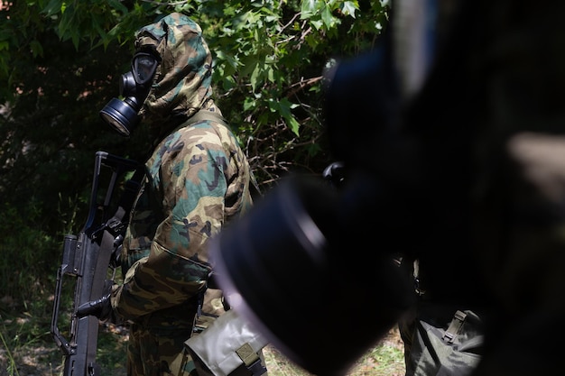 Soldaten mit NBC-Schutzanzügen und Gasmasken während militärischer Übungen