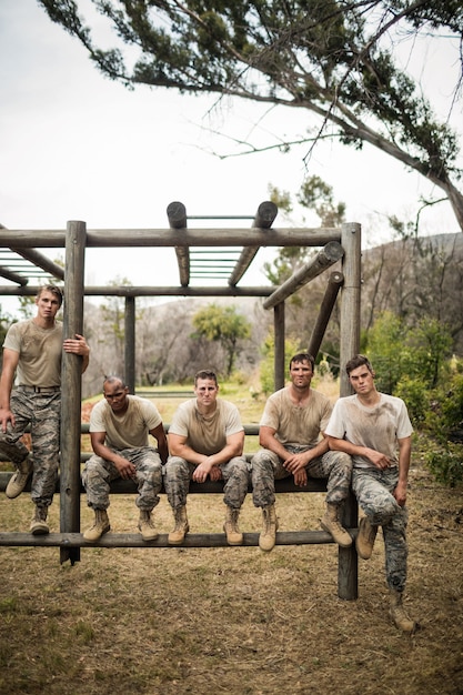 Soldaten sitzen auf dem Hindernisparcours im Bootcamp