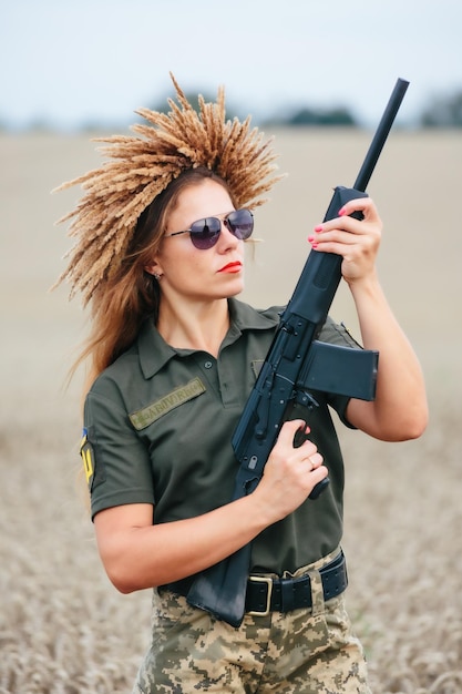 Soldatin in Militäruniform Ein Mädchen in einer Militäruniform mit einer Waffe Ukrainische Frau in einem Kranz