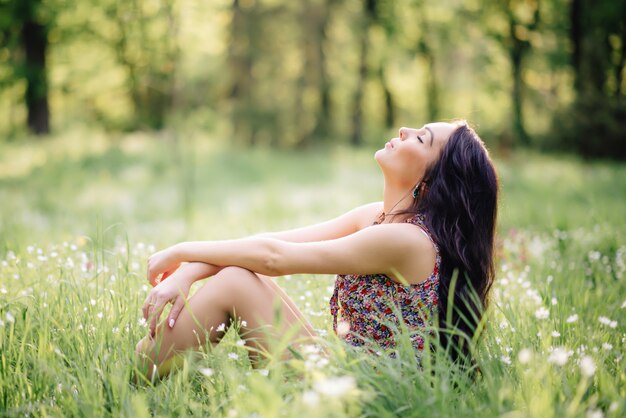 Soleado día de verano, una hermosa joven tirado en el pasto