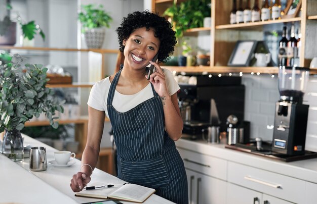 Solicitar más existencias a sus proveedores de confianza Retrato de una mujer joven hablando por teléfono celular mientras trabaja en un café