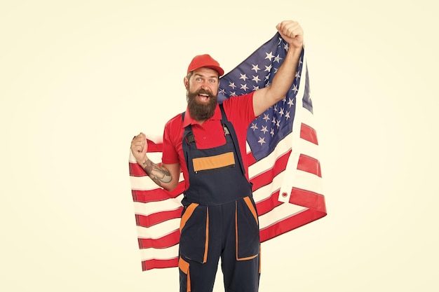 Solicitud de visa de trabajo EE. UU. Hombre trabajador barbudo sostiene la bandera estadounidense Reparación y renovación Consejos de reparación Trabajador de tipo con casco Trabajador regular de constructor Reparación rápida Día del trabajo Reubicación de trabajo en el extranjero