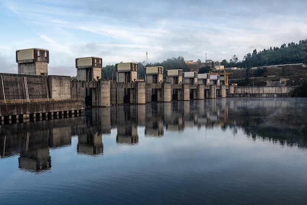 Sólida estructura de la represa Crestuma Lever en el río Duero en Portugal reflejada en aguas tranquilas