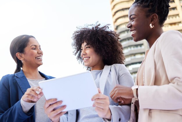 Sollen wir den Erfolg verwirklichen Aufnahme einer gemischten Gruppe von Geschäftsfrauen, die draußen auf dem Balkon stehen und ein digitales Tablet verwenden