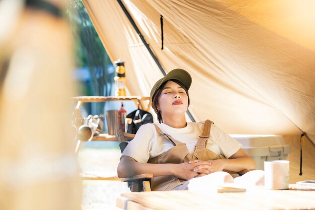 Solo Camp Bild - junge Frau macht ein Nickerchen vor einem Zelt