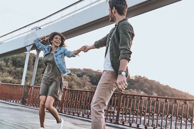 Solo por diversión. Hermosa joven pareja cogidos de la mano y girando