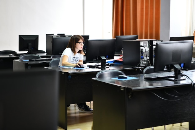 Foto solo una estudiante en el aula de informática y tecnología trabaja y aprende el concepto de persistencia