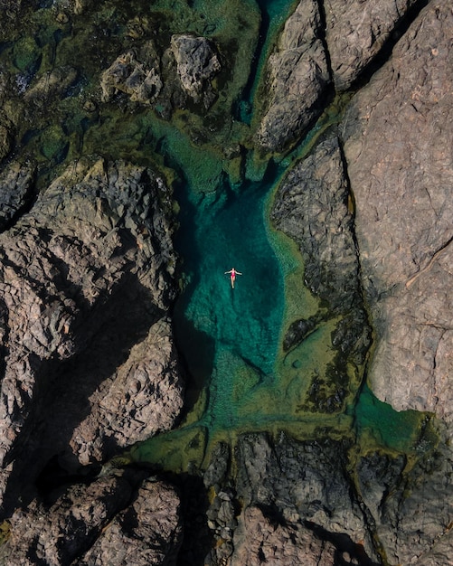 Solo-Mädchen schwimmen im natürlichen Pool des Ozeans auf Fuerteventura