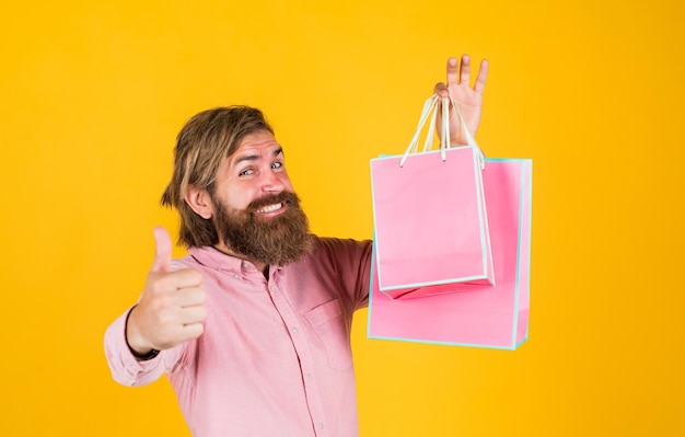 Solo las mejores compras y ventas, hipster brutal maduro con compra presente en el centro comercial, hombre barbudo feliz con paquete de regalo, feliz cumpleaños o aniversario, celebración navideña, sorpresa para él.