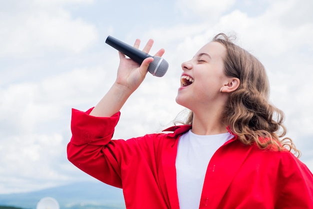 Sólo la música que importa Diviértete en la celebración adolescente niño cantando con micrófono en karaoke niño cantando al aire libre cantante con micrófono infancia feliz niña feliz disfruta el momento