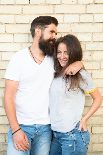 Solo pasar el rato juntos. Pareja enamorada. Pareja familiar abrazándose en el fondo de la pared de ladrillo. Hombre barbudo y mujer sexy abrazándose. Sensual pareja juntos. Dia familiar. Abrazo cuidadoso de gente amorosa.