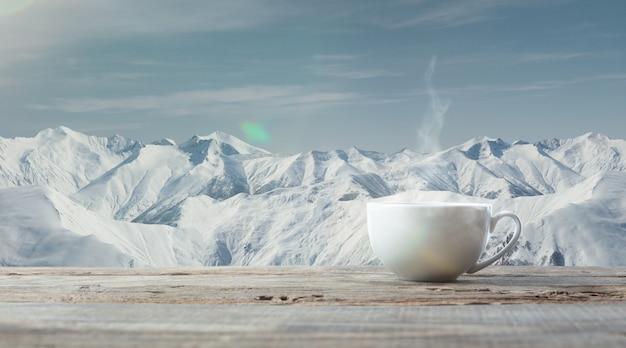 Solo taza de té o café y paisaje de montañas en el fondo. Taza de bebida caliente con aspecto nevado y cielo nublado frente a él. Cálido en días de invierno, vacaciones, viajes, Año Nuevo y Navidad.