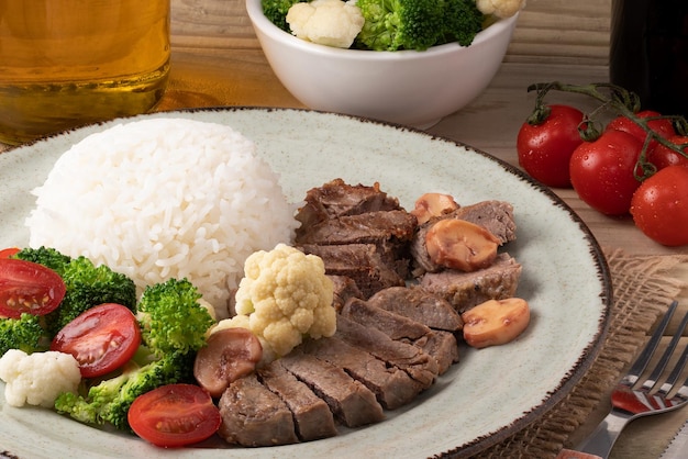 Solomillo con arroz y ensalada de coliflor con tomate y brócoli