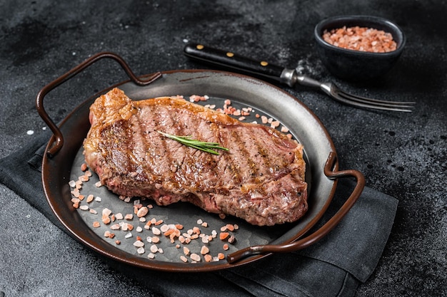 Solomillo a la parrilla o bistec de carne de res de Nueva York con sal rosa y hierbas Fondo negro Vista superior