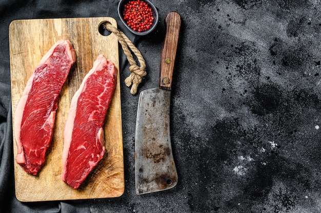 Solomillo de ternera en una tabla de cortar. Carne de vacuno ecológica. Fondo negro