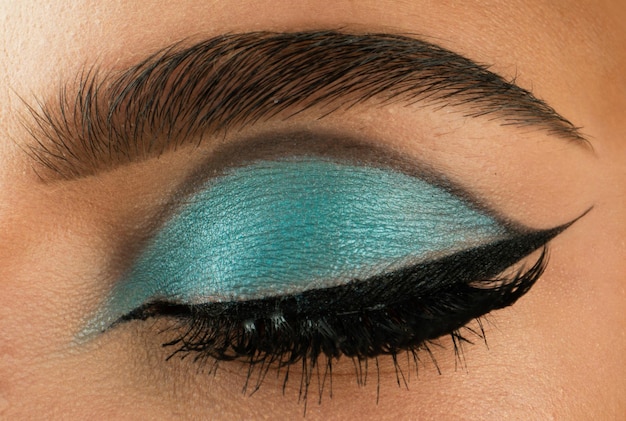 Sombra aplicando maquiagem para olhos closeup modelo feminino olho com maquiagem de moda conceito de beleza macr