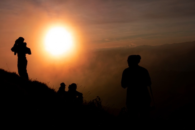 Sombra de mulheres no topo da montanha Durante o pôr do sol