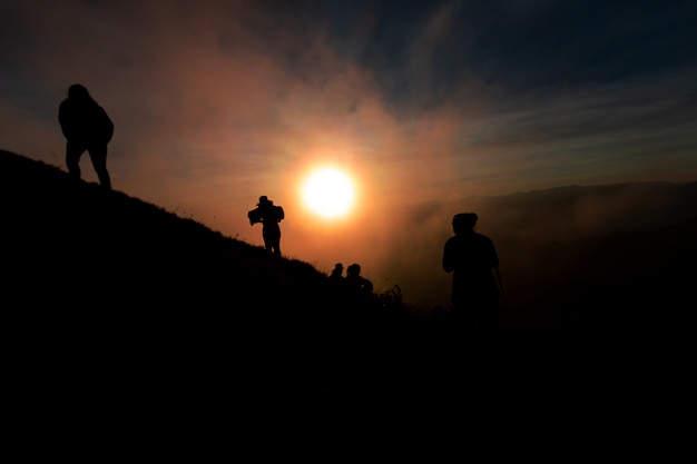 Sombra de mulheres no topo da montanha Durante o pôr do sol